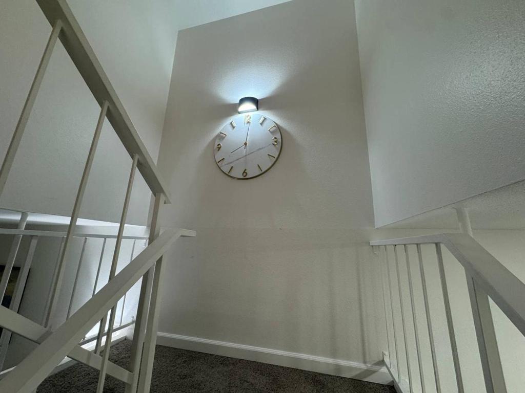a clock on a wall with a light on the wall at 4BR Luxury, Walk to Old Town, Arcade, Pool, 12 Guests in Scottsdale
