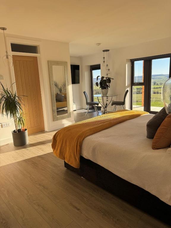 a large bedroom with a large bed with windows at Turnpike House in Glanton