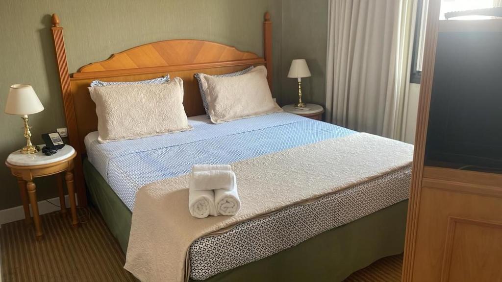 a bedroom with a bed with two towels on it at Hotel Estanpla Moema Ibirapuera com garagem piscina 1004 in Sao Paulo