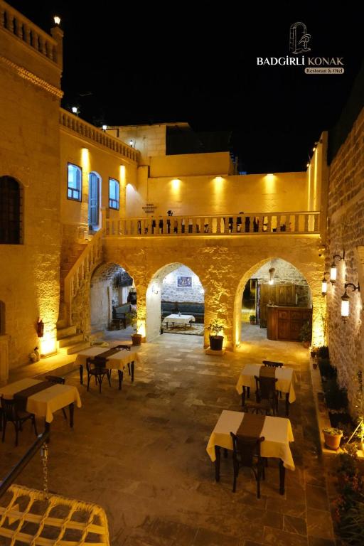 an outdoor patio with tables and a bridge at night at Badgirli Konak in Urfa