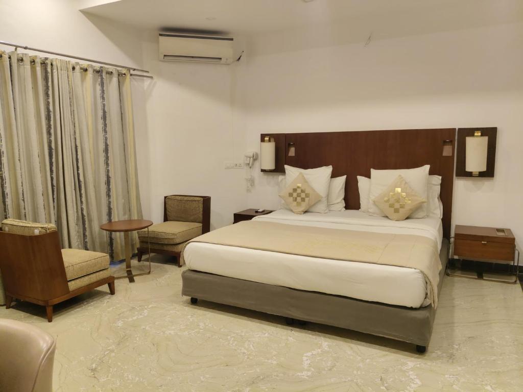 a bedroom with a large bed and a chair at Dhuki beach paradise in Chennai