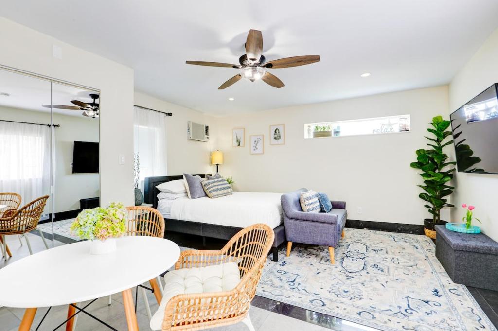 Una sala de estar con una cama, una mesa y sillas. en La Moderna - A Private Guesthouse, en Hollywood