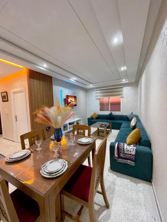 a living room with a table and a blue couch at Sunset Vibes Larache in Larache
