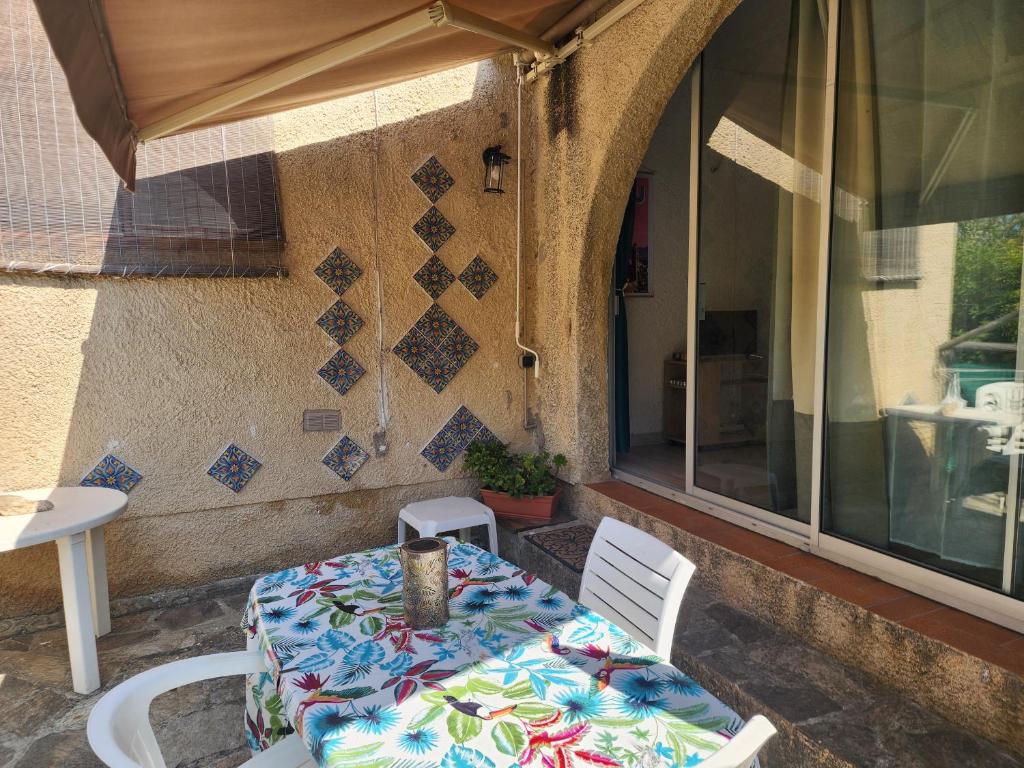 a table and chairs sitting outside of a building at Charmant 3 pièces terrasse climatisé bord de mer in Lumio