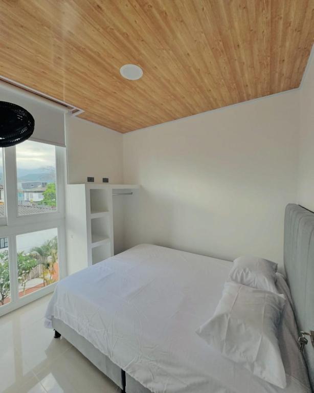 a bedroom with a bed with a wooden ceiling at Aparta Hotel Los Agustinos in Acacías