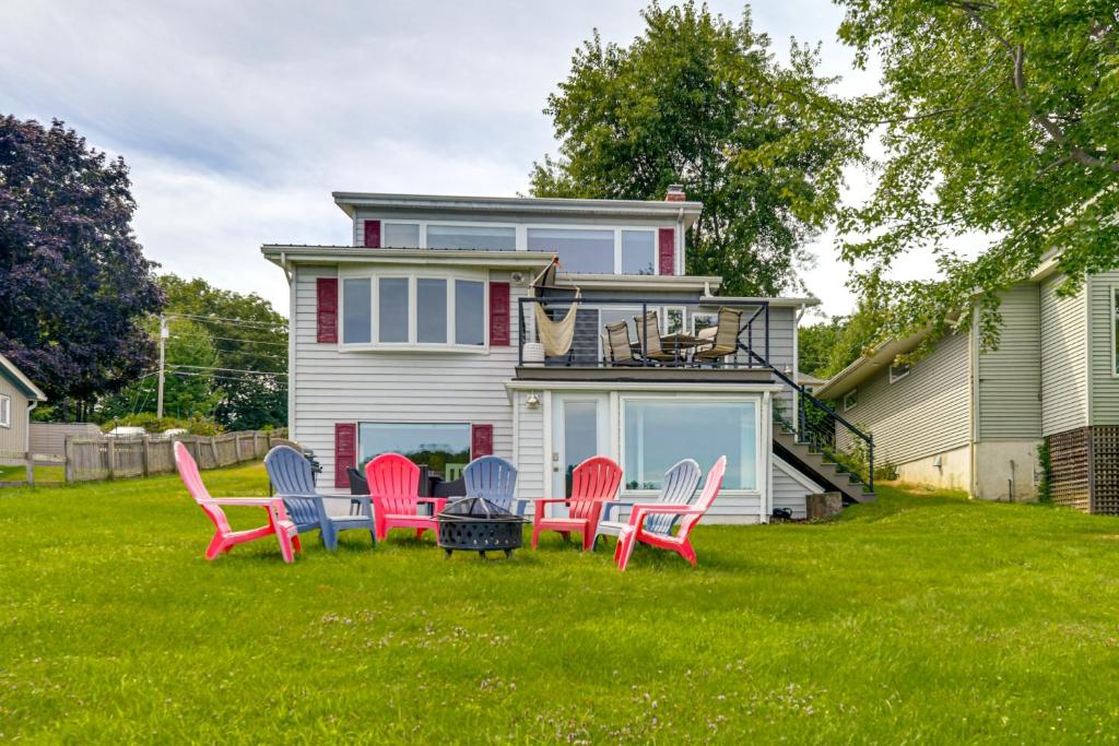 a group of chairs sitting in the grass in front of a house at Ice Fish and Explore! Lake Champlain Family Retreat in Colchester