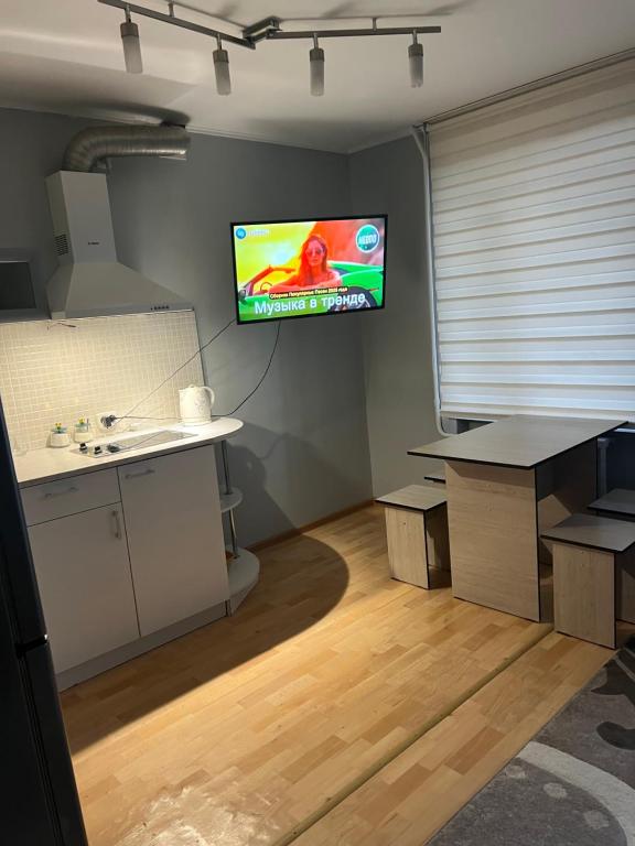 a living room with a tv on the wall at Квартира на Казахстан 72 in Ustʼ-Kamenogorsk