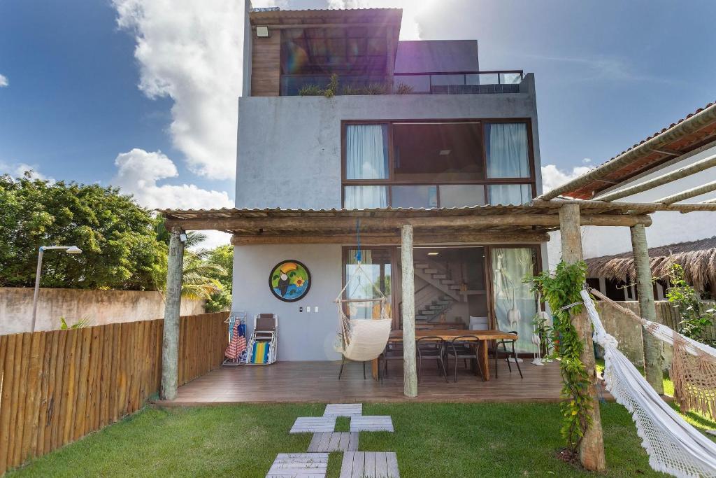 een huis met een houten terras met een tafel bij Piscina e serviço incluído na Rota dos Milagres in Tatuamunha