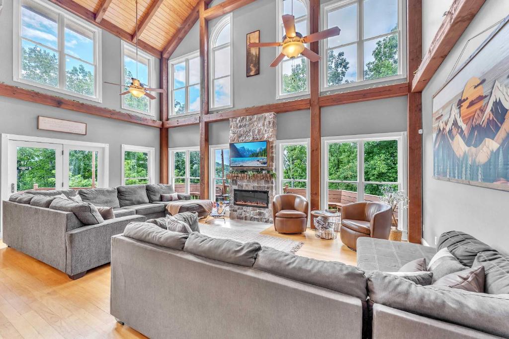 ein großes Wohnzimmer mit Sofas und einem Kamin in der Unterkunft The Retreat at Wildwood - Hot Tub Theater & Deck in Wildwood