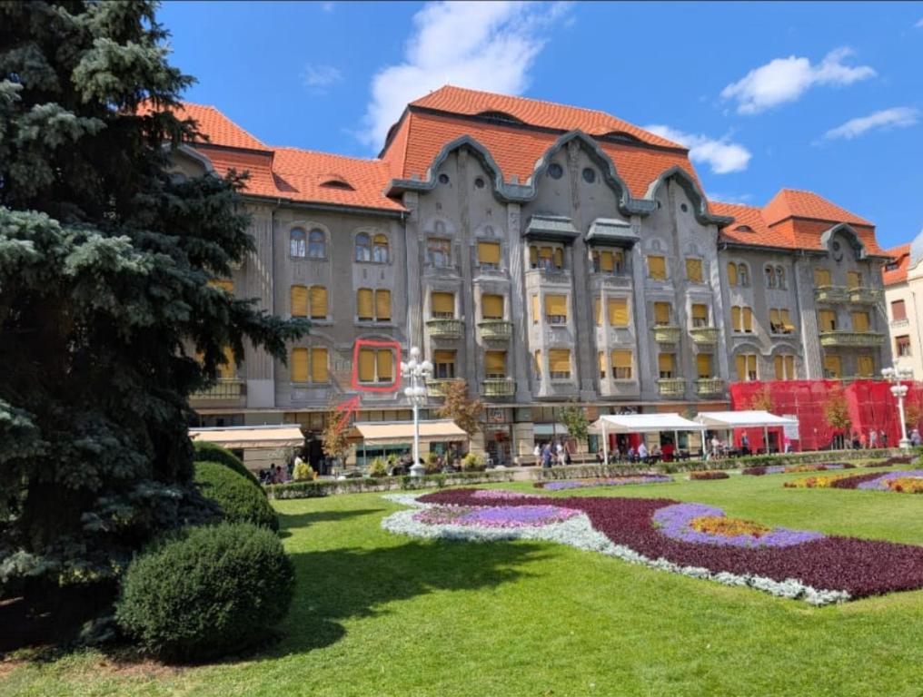 a large building with a garden in front of it at Ultra-central apartment in the Dauerbach Palace in Timişoara