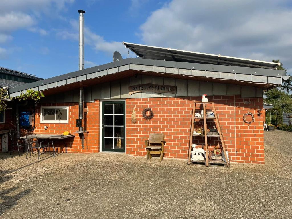 a small brick building with a ladder in front of it at Kaminstube Hof Friebe in Reken
