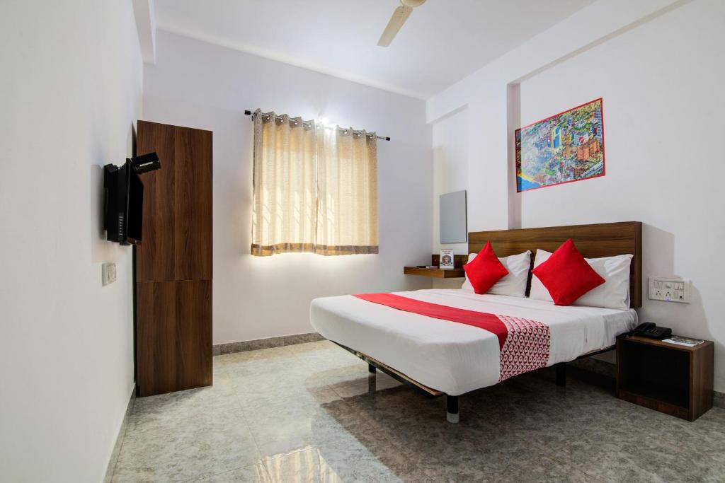 a bedroom with a large bed with red pillows at Hotel O Varcity Comforts Near St. John Medical College in Bengaluru
