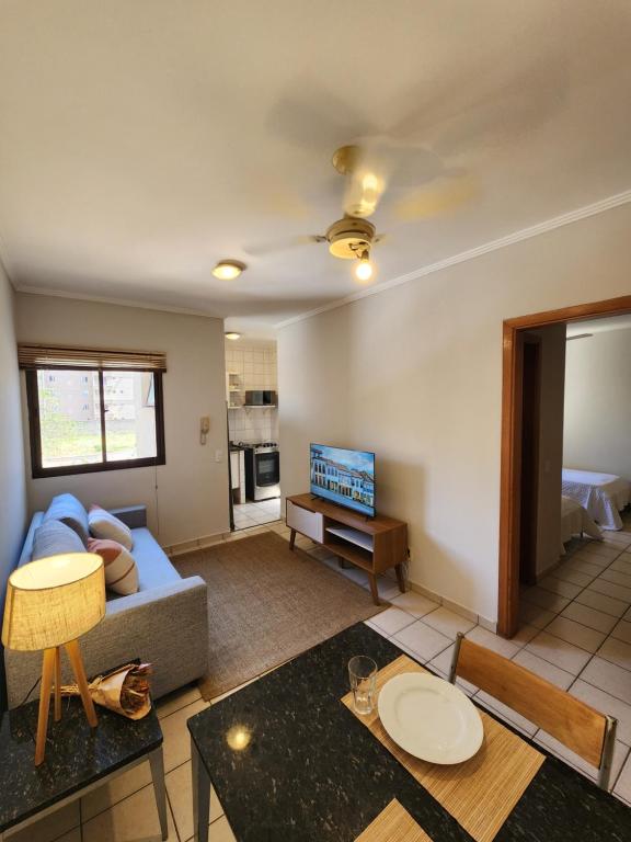 een woonkamer met een bank en een tafel bij Apto 237 super bem localizado in Ribeirão Preto