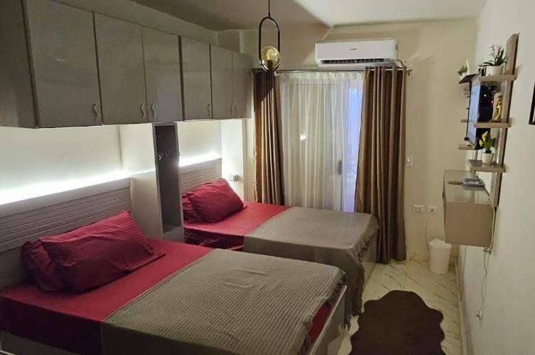 ein kleines Zimmer mit zwei Betten und einem Fenster in der Unterkunft Studio Carmen with a Pool View in El-Alamein