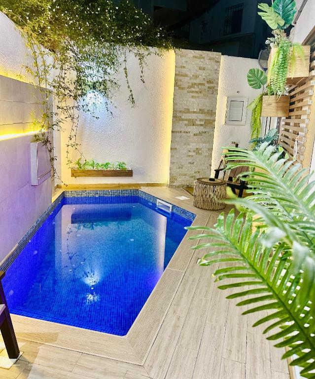 a swimming pool in the middle of a room with plants at DARZAYNAH in Monastir