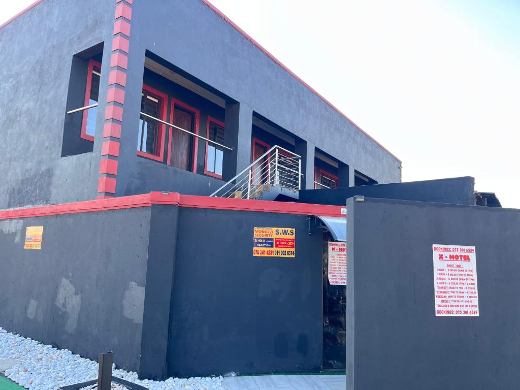 a building with red windows on the side of it at X-Motel Voslo in Johannesburg
