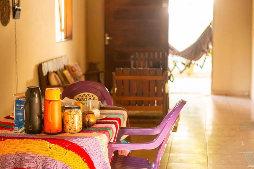 a table with a colorful table cloth with food on it at Casa de Hospedagem Cajueiro in Jijoca de Jericoacoara
