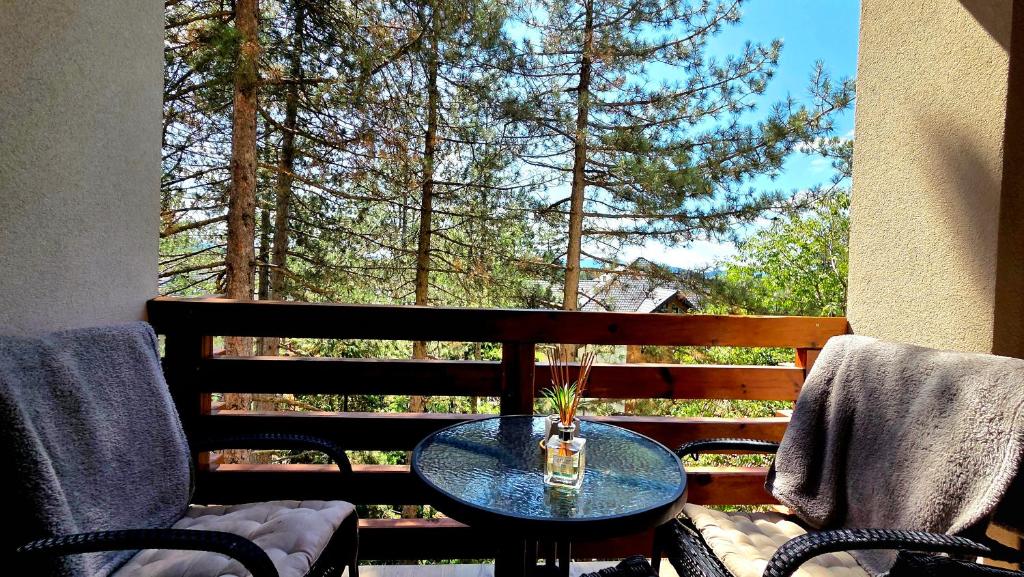 a table and chairs on a balcony with a window at Apartman Silver Lux in Zlatibor