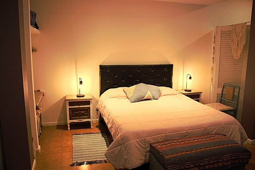 a bedroom with a large bed and two lamps at "Clodin" Monoambiente Ideal, Planta Baja y Garage in La Cieneguita