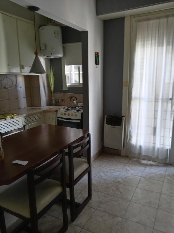 eine Küche mit einem Holztisch und einem Tisch und Stühlen in der Unterkunft 1 Ambiente Zona Shopping Aldrey in Mar del Plata