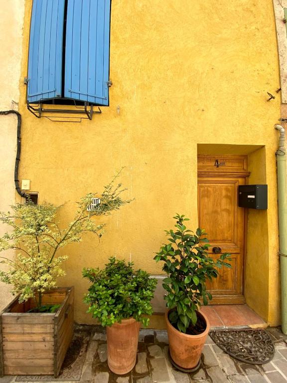 a building with two potted plants in front of a door at Maison tout confort à Gémenos Calanques & Cassis in Gémenos