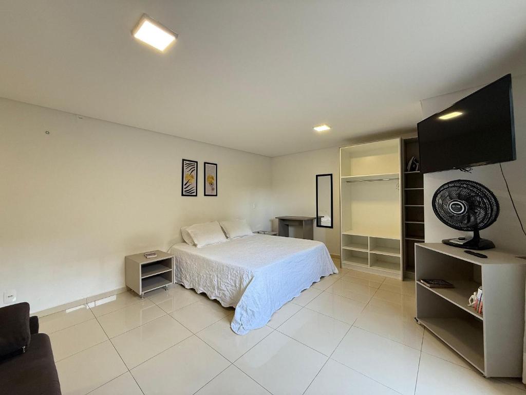 a bedroom with a bed and a flat screen tv at Studio Charmoso Próximo ao Parque do Lago - SPMA01 in Guarapuava