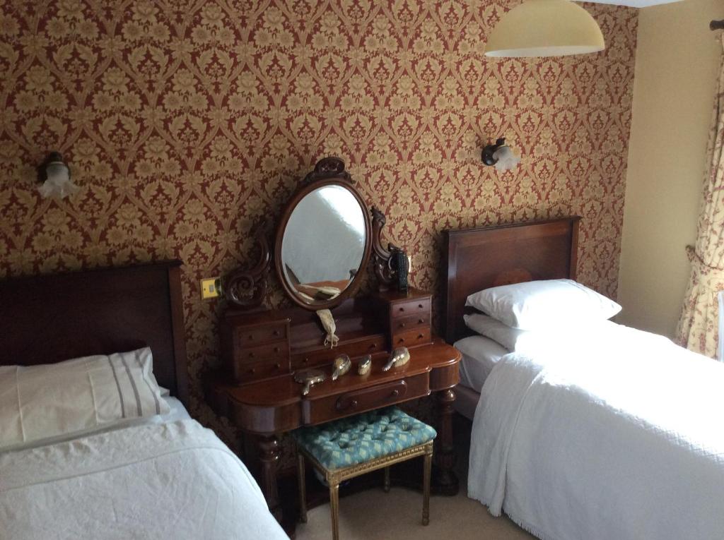 a bedroom with two beds and a mirror and a dresser at Marsh Mere Lodge in Arthurstown