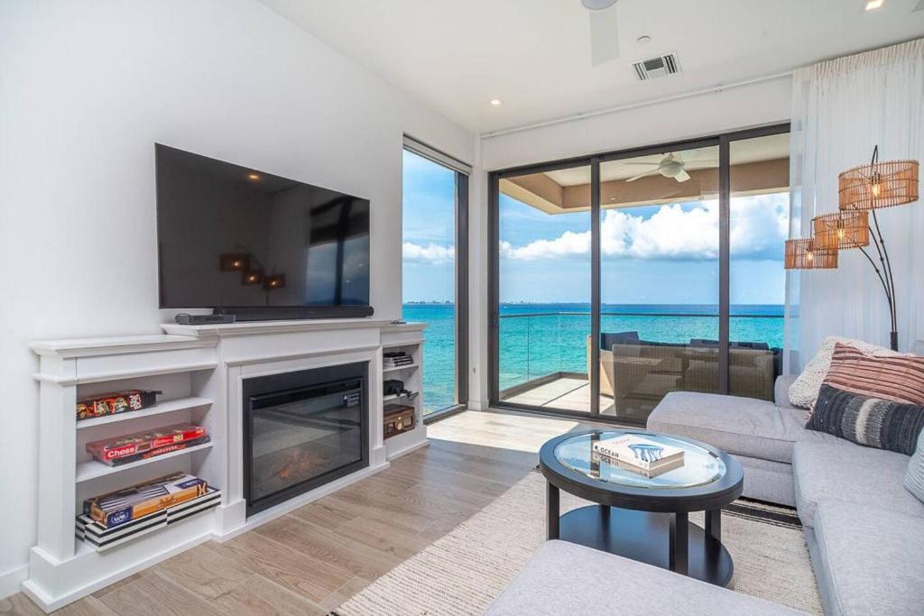 a living room with a fireplace and a tv at Sea Dreams 3-contemporary Condo Wpanoramic Views in West Bay