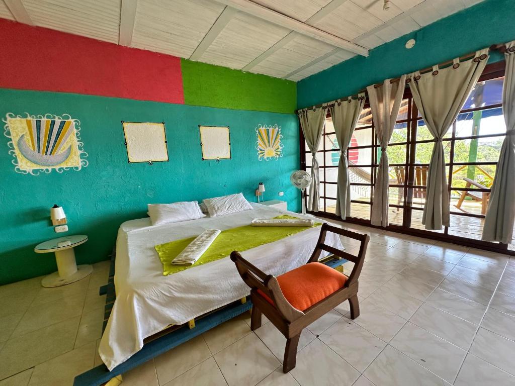 sypialnia z łóżkiem i krzesłem w pokoju w obiekcie Tayrona Colors Hostel w mieście Taganga