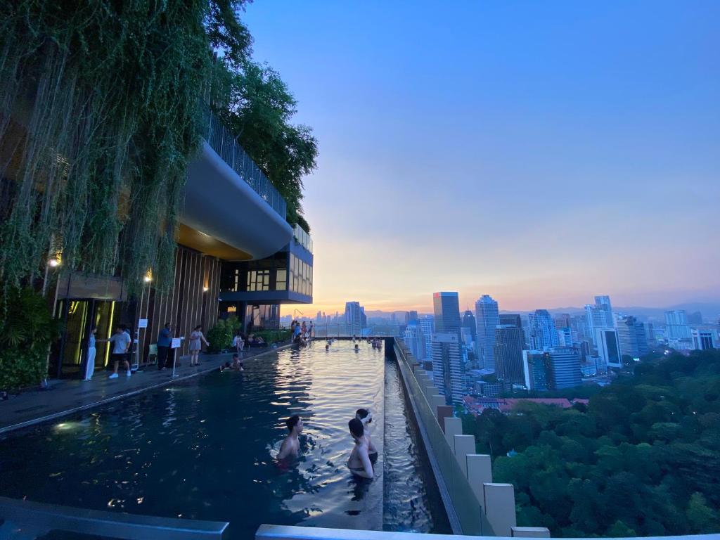 a swimming pool in a building with a city in the background at Ceylonz Suites by Stayla in Kuala Lumpur