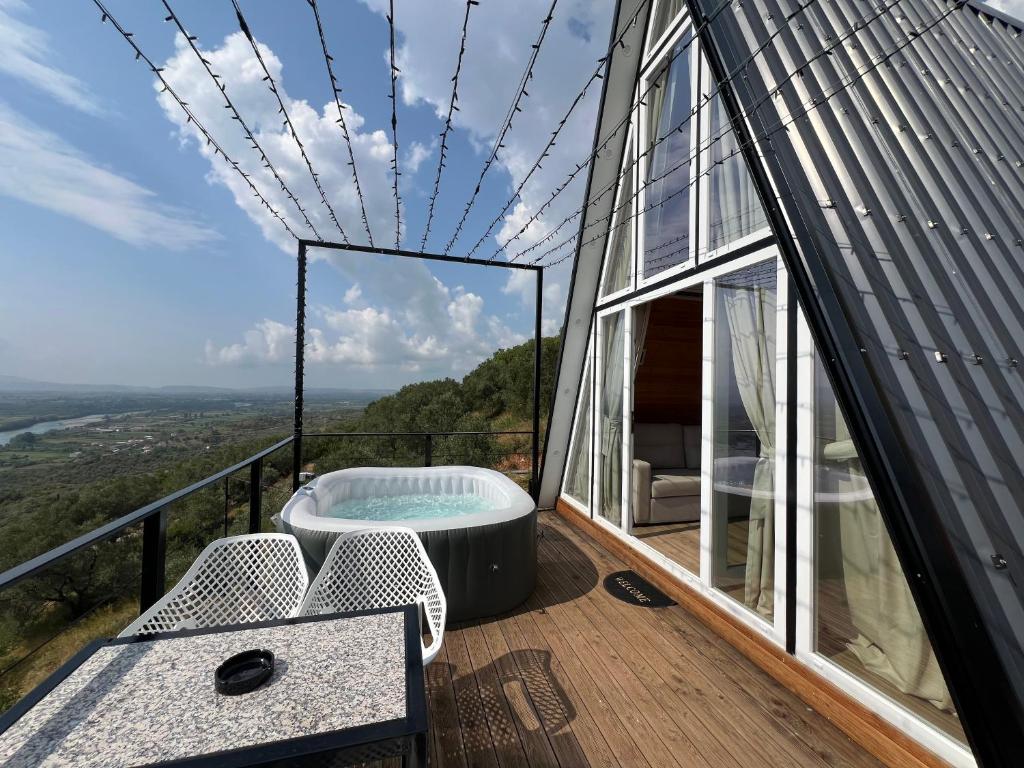 a glass house with a hot tub on the deck at Doel House Zues - Hot Tub Villa & Scenic View in Shkodër