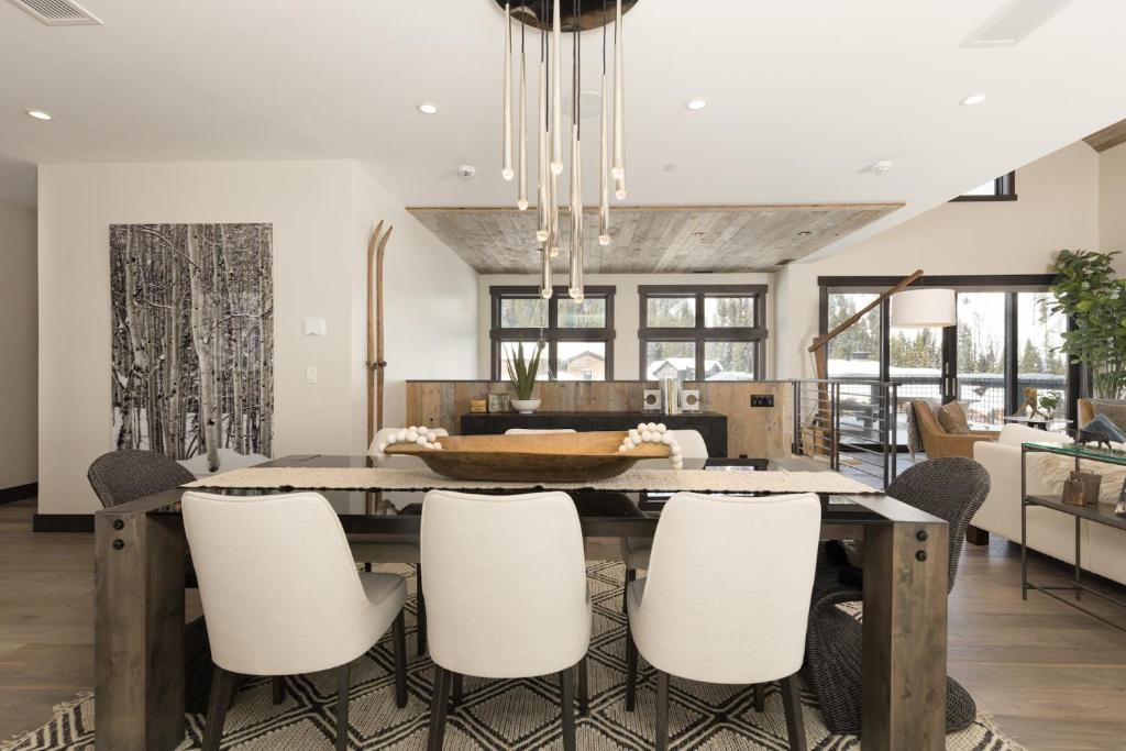 a dining room with a table and white chairs at Spanish Peaks | Highlands Cabin 36 in Big Sky