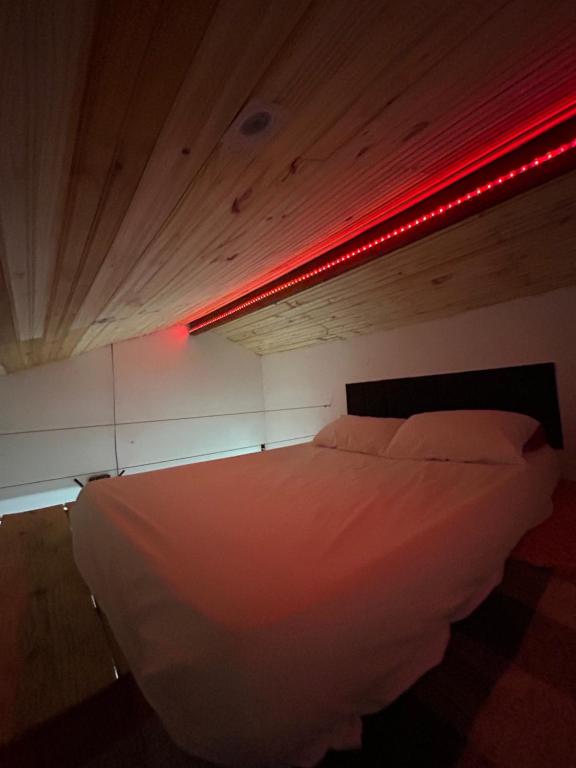 a bedroom with a bed with a red light at Chalé Jorge in São Thomé das Letras