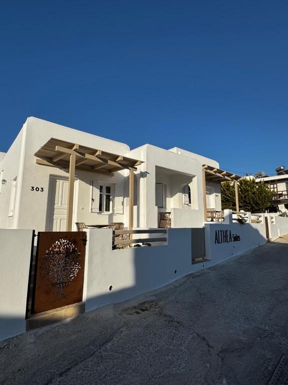 a white house with a sign on the side of it at ALTHEA suites in Naousa