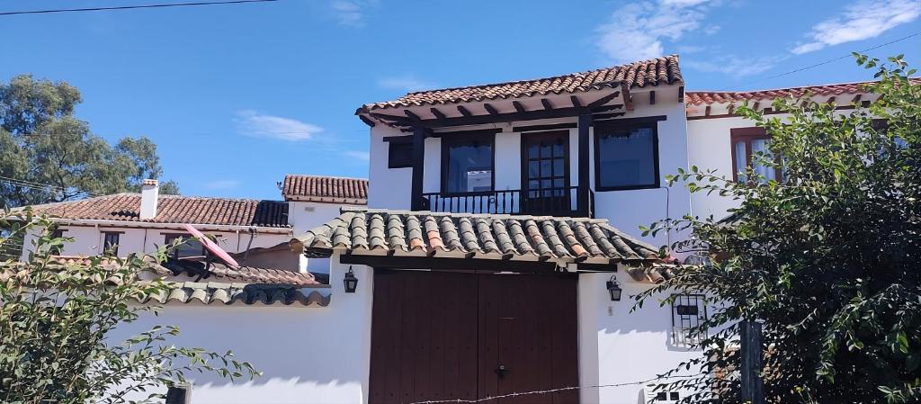 ein weißes Haus mit einem Tor und einem Dach in der Unterkunft Casa Encanto in Villa de Leyva