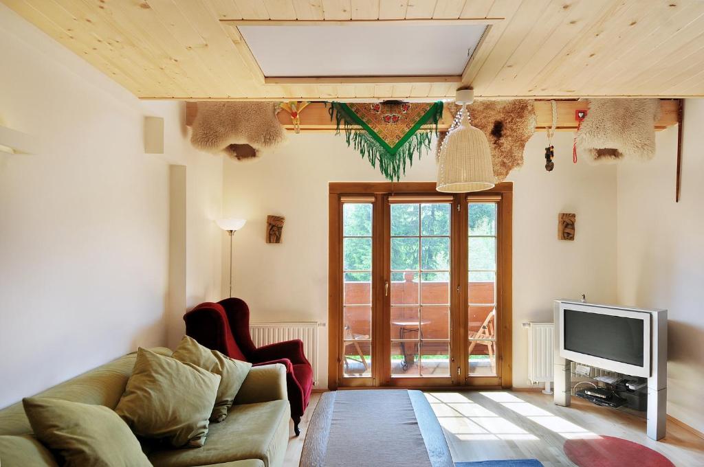 a living room with a couch and a tv at Apartamenty Tatrzańskie Turnie in Zakopane