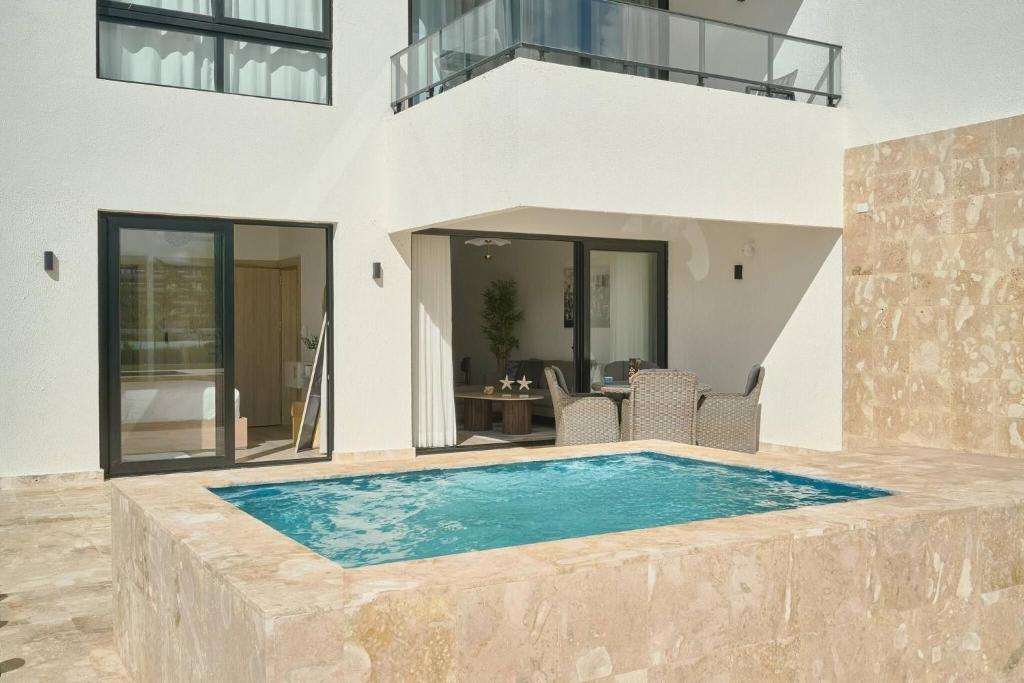 a villa with a swimming pool in front of a house at Luxury Escape Private Jacuzzi, Beach, Punta Cana SLEEP 5 in Punta Cana