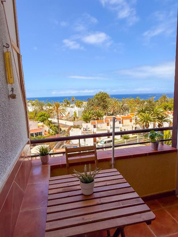 a wooden bench on a balcony with a view of the beach at Piso los Agaves in Costa de Adeje