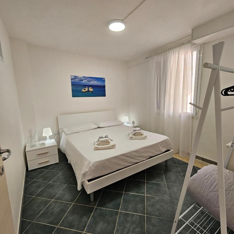 a white bedroom with a bed and a window at Casa Vacanze AFEA Torre dell'Orso Salento Puglia in Torre dell'Orso