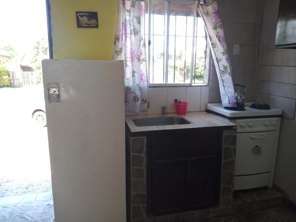 eine Küche mit einem weißen Kühlschrank und einer Spüle in der Unterkunft CABAÑITAS del sur in Mar del Plata