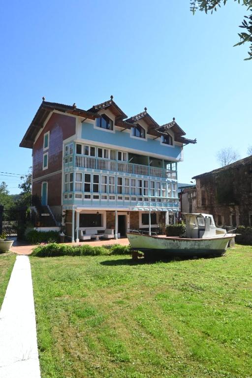 a large house with a boat in front of it at La casa del agua Cantabria in Ampuero