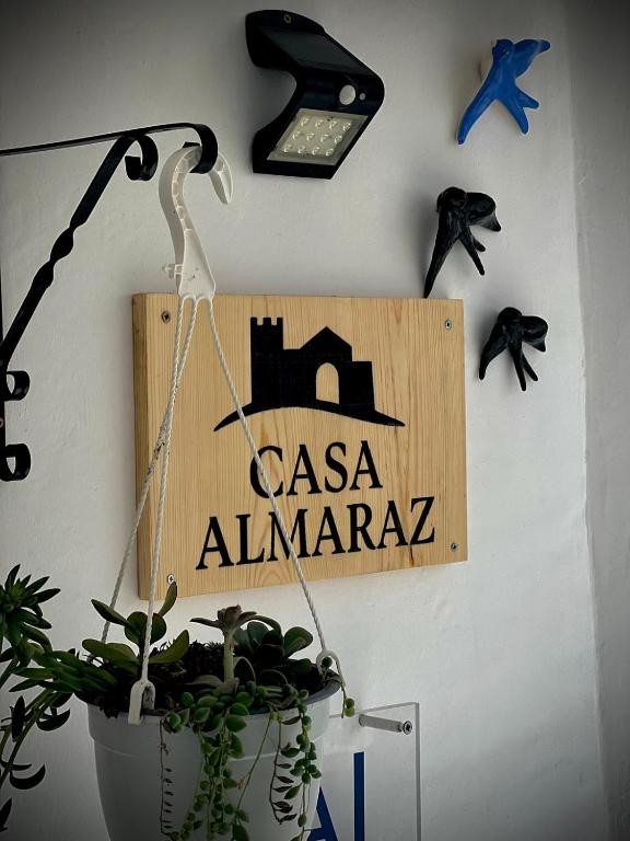 a sign hanging on a wall with a potted plant at Casa Almaraz in Reguengos de Monsaraz