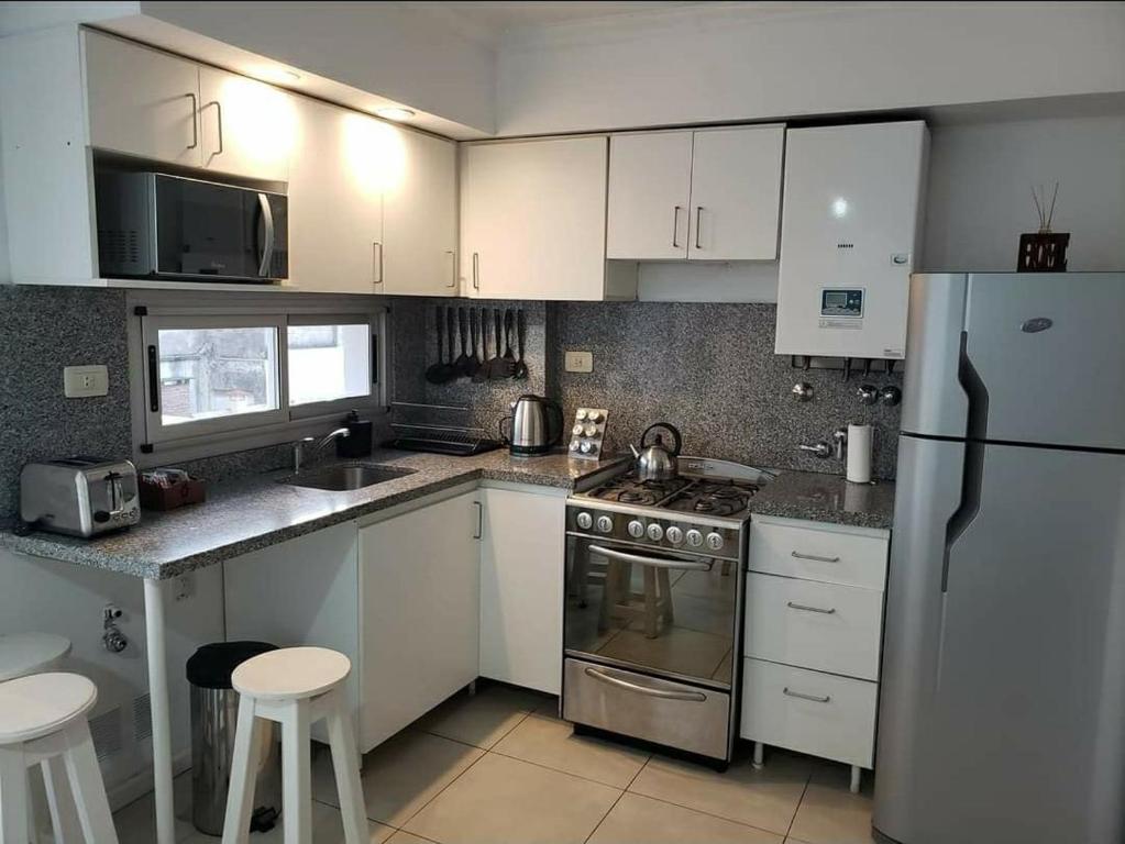 a kitchen with white cabinets and stainless steel appliances at Depa pleno centro Santa Fe in Santa Fe