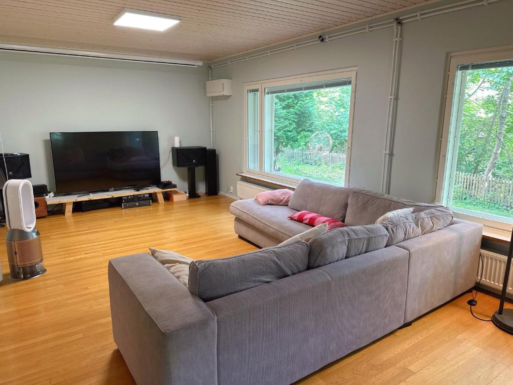 un soggiorno con divano e TV a schermo piatto di Natural Cottage a Kauniainen