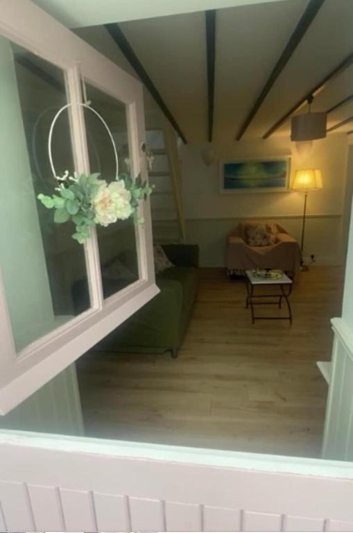 a living room with a green couch and a window at Horseshoe Cottage, Killarney in Killarney