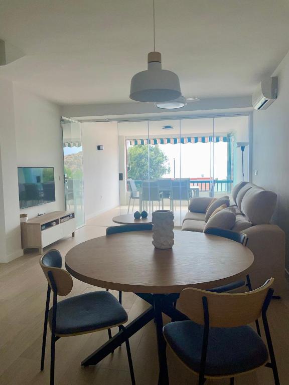 a living room with a table and chairs and a couch at Dúplex Frente al Mar - Salobreña in Salobreña