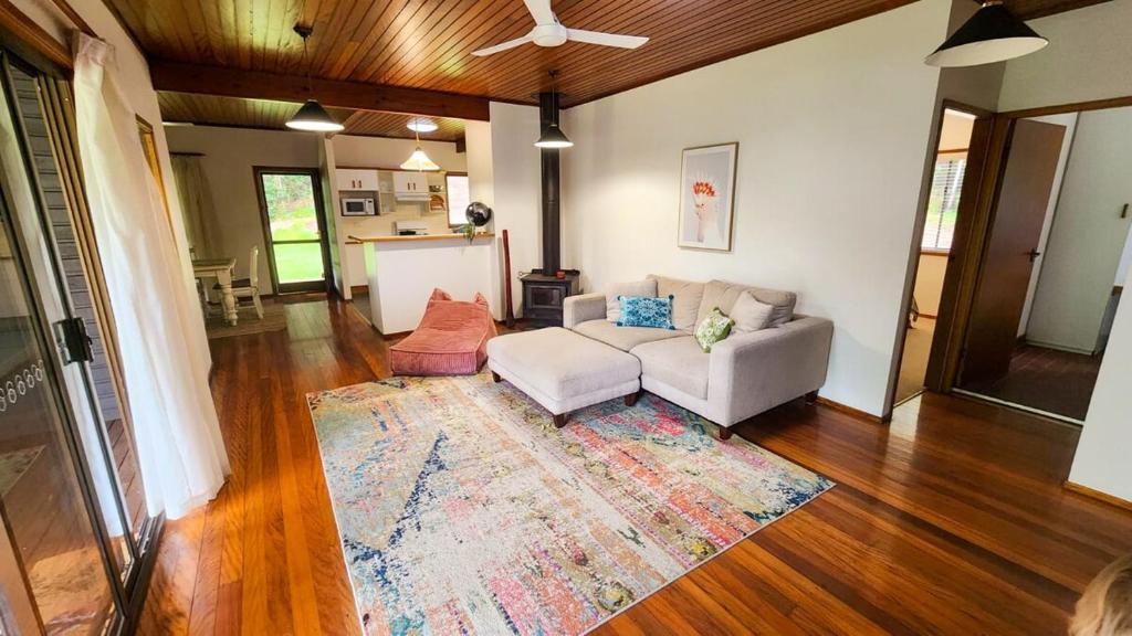 a living room with a couch and a rug at Thrums Bush Retreat in Upper Orara