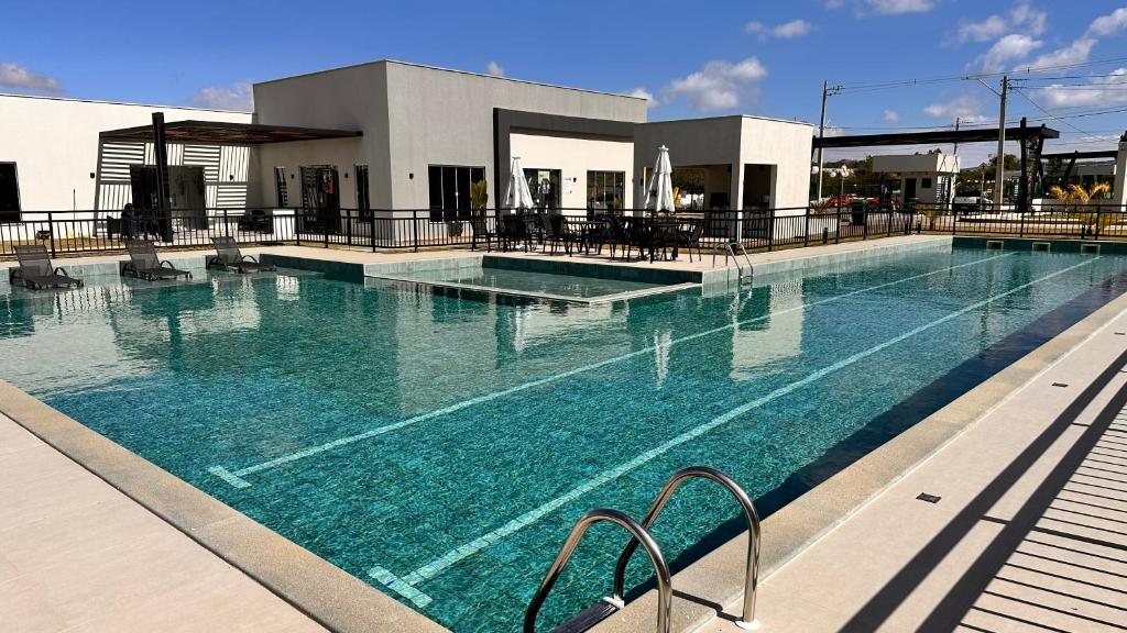 a swimming pool with blue water in front of a building at Dona Olivia Universidade in Vitória da Conquista