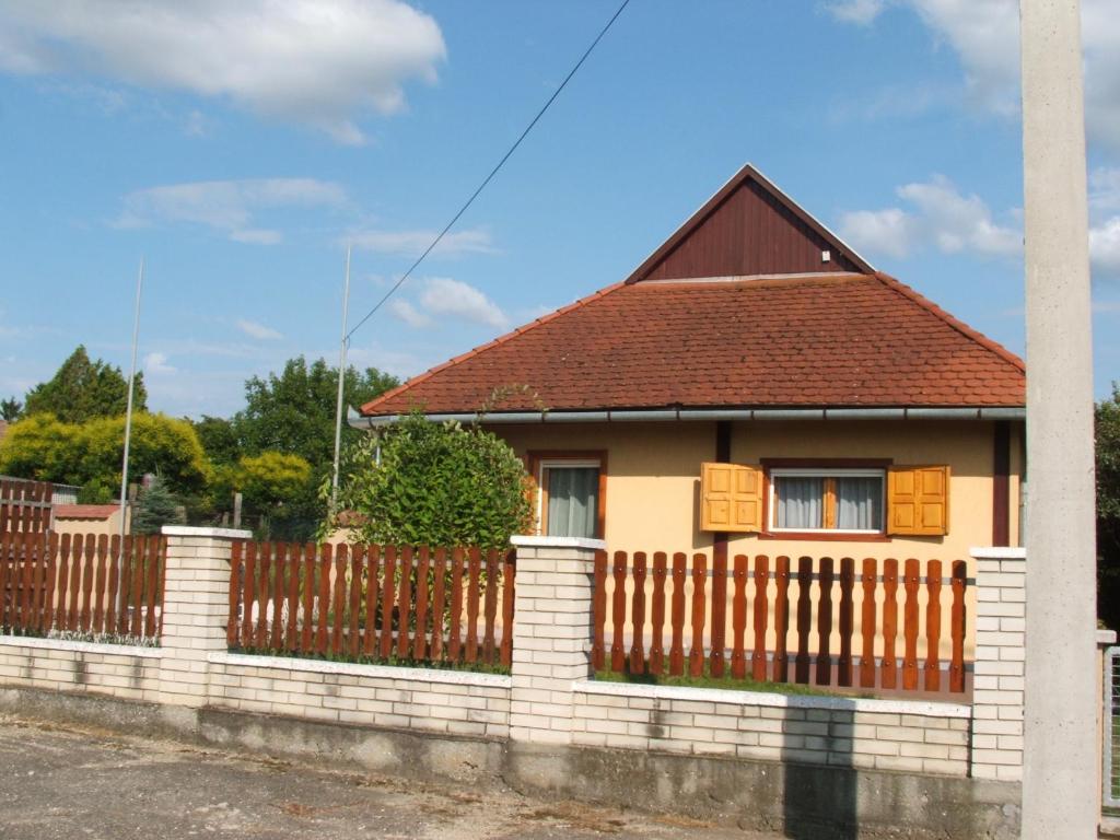una casa con una valla delante de ella en Zsiga Apartmanház en Balatonszabadi
