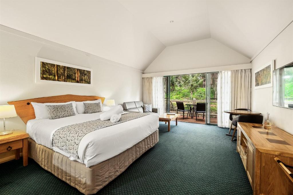 a bedroom with a large bed and a large window at Heritage Trail Lodge in Margaret River Town
